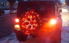 a jeep that has some lights on in the back of it's trunk and tire