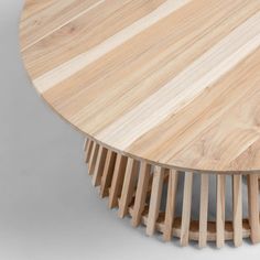 a round wooden table with several sections stacked on it's sides and the top section is made out of thin strips of wood