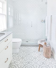 a bathroom with white and gray tiles on the floor