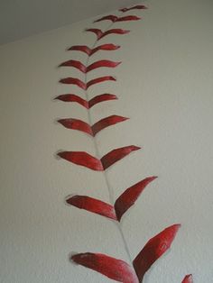 a painting of a red plant on a white wall