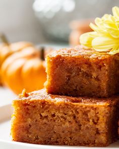 three pieces of cake sitting on top of a white plate next to a yellow flower