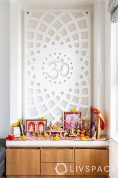 a table with pictures and other items on it in front of a large white wall