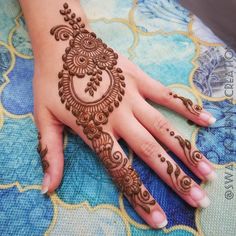 a woman's hand with henna tattoos on it