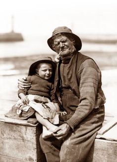 an old black and white photo of a man holding a child