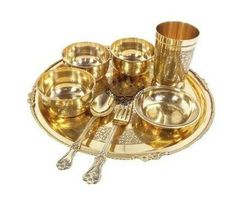 gold plate with silver cups and spoons on it