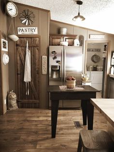 a kitchen with wooden floors and an old style refrigerator freezer combo in the center