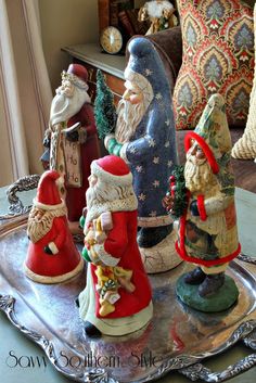 christmas figurines sitting on top of a silver tray