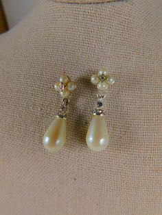 Elegant faux pearl and crystal drop earrings in silvertone settings. Studs have four small pearls with crystal in the center...drops have a cap with surround of clear crystals. Earrings drop about 1" from point of skin contact. Very minor wear, if any...not visible. NOTE: They appear yellowed in the photos, but they are white. Beautiful vintage condition. Cream Pearl Drop Earrings For Formal Occasions, Formal Cream Pearl Earrings, Vintage Teardrop Pearl Earrings, Anniversary Pearl Drop Teardrop Clip-on Earrings, Anniversary Teardrop Pearl Drop Clip-on Earrings, Crystal Drop Earrings Wedding, Drop Earrings Wedding, Crystals Earrings, Mother Of Bride