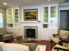 a living room filled with furniture and a fire place under a painting on the wall