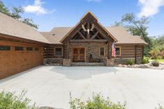 a large house with an american flag on the front door and two garages behind it