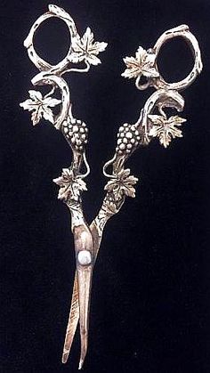 two pairs of scissors with flowers and leaves on them, sitting side by side in front of a black background