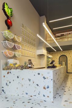 the interior of a restaurant with white counter tops and colorful plates on the wall above it