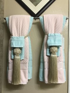 two towels hanging on the wall with tassels