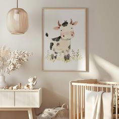 a baby's room with a cow painting on the wall