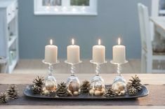 a tray with candles and pine cones on it