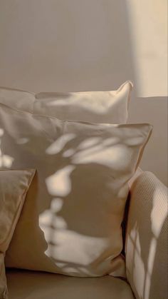 two white pillows sitting on top of a couch