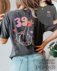 "I Am 39+ Middle Finger Shirt, Personalized 40th Birthday Tshirt, Custom 1984 Birthday Party T-Shirt, Funny I Am 39 Plus T Shirt, 40 Bday Tee HOW TO ORDER ➀ Select color ➁ Select the size (Please check size chart) ✦ True to size. Size up 1-2 sizes for an oversized look. ➂ Add to cart ✦ (Optional) \"Add message to Seller\" on the checkout page. GARMENT FEATURES ✦ Crew neckline ✦ Direct to garment printing - no vinyl, decal, or iron-on technique ✦ Our designs are printed on the garment to last a long time and may not appear as 'glossy' or saturated as iron-on designs are. ✦ Please note that colors may appear different on different digital screens and may not be a true representation of the actual colors. ✦ Additional T-Shirt Colors and Sizes Available Upon Request ✧✧Brands: Bella Canvas Unis 30th Birthday Tshirt, Banquet Outfit, 1984 Birthday, Tshirt Custom, Band Mom, 1st Birthday Shirts, Birthday Planning, Future Mrs, Birthday Tshirts