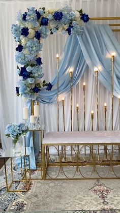 a gold bench with blue flowers and candles