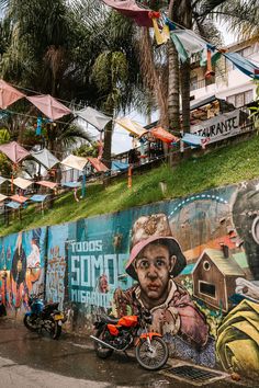 a mural on the side of a building with a motorcycle parked in front of it