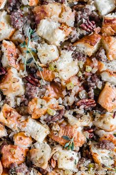 closeup of stuffing in a casserole dish with fresh herbs on the side