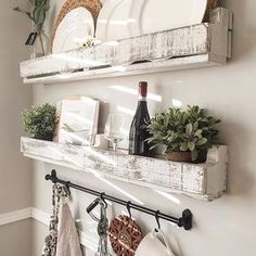 two white shelves holding dishes and wine bottles