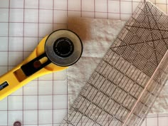 a pair of scissors sitting on top of a piece of fabric next to a ruler