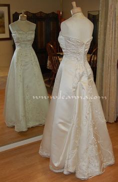 two wedding gowns on mannequins in front of a mirror