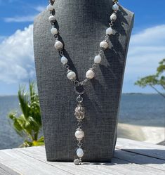 This freshwater pearl necklace is paired with moonstone faceted crystals and adorned by silver tone accents.  There are 11 freshwater creamy white freshwater baroque pearls on this lariat style necklace. The pearls range in size from 9-12mm. Each pearl has it's own personality and character traits that make them "perfectly imperfect." The baroque artisans described these unique pearls in this way and I couldn't agree more.  I love mixing pearls with other beads to create designs that can be worn White Baroque Pearl Lariat Necklace, Bohemian Silver Pearl Charm Necklace, Bohemian Silver Pearl Necklace With Charm, Silver Bohemian Pearl Drop Necklace, Bohemian Pearl White Necklace With Pearl Pendant, Silver Beaded Long Necklace With Pearl Drop, White Pearl Lariat Jewelry, White Pearl Drop Lariat Jewelry, White Adjustable Lariat Necklace With Pearl Pendant