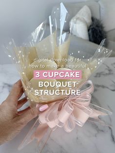 a hand holding a cake bouquet with the words 3 cupcake bouquet structure on it