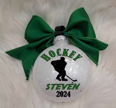 a hockey ornament with a green bow on it's head and name