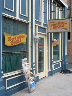 there is a store front on the side of the street that has been painted blue and yellow