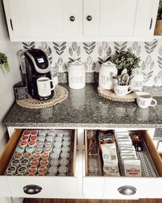 an organized kitchen counter with coffee cups and mugs in the bottom drawer on top