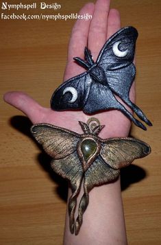 a person's hand with two moths on it and an eyeball in the palm