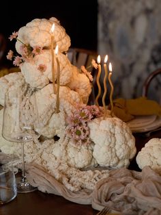 a table topped with cauliflower and candles