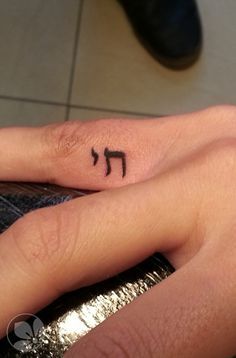 a person with a small tattoo on their finger