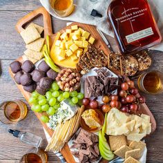 an assortment of wine, cheese and crackers on a wooden table