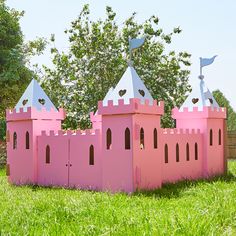 a pink castle made out of cardboard sitting in the grass