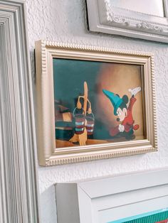 a framed mickey mouse painting hanging on the wall