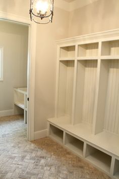 an empty room with white shelves and a chandelier