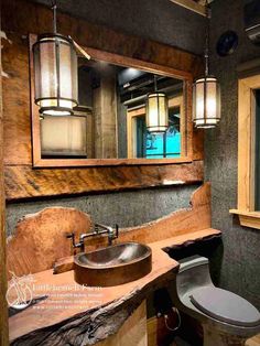 a bathroom with a toilet, sink and mirror in it's wood paneled walls