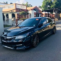 a black car parked in front of a house