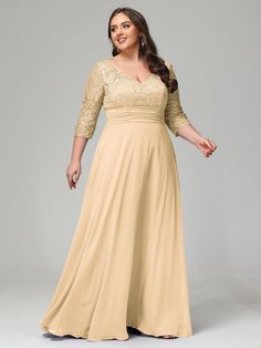 a woman in a long beige dress posing for the camera with her hands on her hips