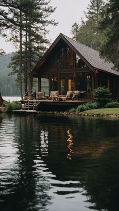 a house sitting on top of a lake next to a forest