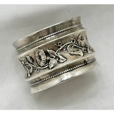 a silver ring with flowers and leaves on it