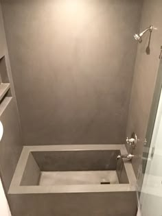 a bathroom with a tub, toilet and shower head in the corner is shown from the inside