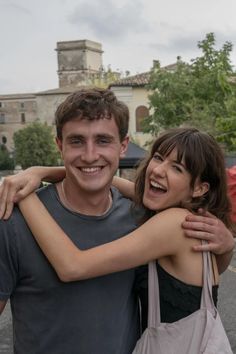 a man and woman hugging each other in the street