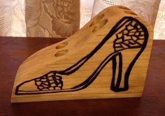 a wooden shoe shaped box sitting on top of a table next to a lace curtain