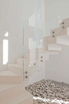 there is a white staircase with rocks on the bottom and an open window above it