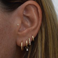 a close up of a person's ear with three different types of piercings