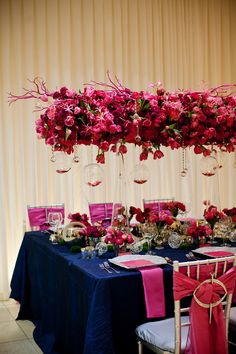 the table is set up with pink flowers and wine glasses for an elegant wedding reception